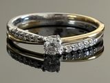 a close up of a diamond ring on a reflective surface