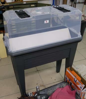 une petite table sur laquelle se trouve un récipient en plastique
