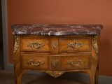 a wooden chest of drawers with a marble top