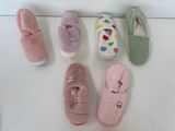 Plusieurs paires de chaussons sont alignées sur une surface blanche