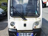 un petit véhicule blanc garé sur un parking