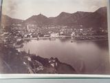 a black and white photo of a lake and a city