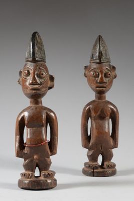 deux figurines en bois représentant deux hommes coiffés d'un chapeau
