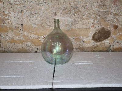 a glass vase sitting on a table with a crack in it