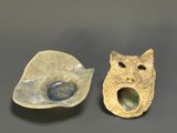 two pieces of pottery that have been made to look like cats