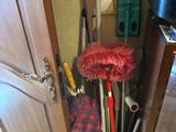 a picture of a bunch of brooms that are in a cabinet