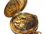 a gold pocket watch that is open on a white background