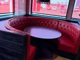 une cabine rouge avec une table ronde et des chaises rouges