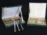 deux sets d'argenterie dans un coffret sur une table
