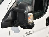a white van with a black side mirror and a plastic bag on the side of the van
