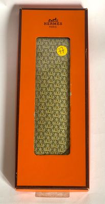 an orange box with a green tie in it on a white surface