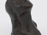 un gros plan sur une sculpture représentant une tête de femme posée sur une surface blanche