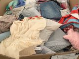 une boîte en carton remplie de vêtements posée par terre