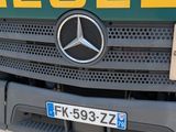 a green and yellow mercedes truck parked in a parking lot