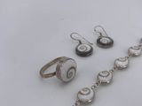 a bracelet, ring, and earring set on a table