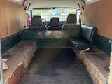 doorway view of a van with seats and a bench in the back