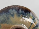 a close up of a ceramic vase with a brown rim