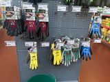 many gardening gloves on display in a store