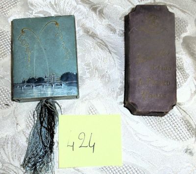 deux vieux livres posés sur une table, avec un mot accroché dessus