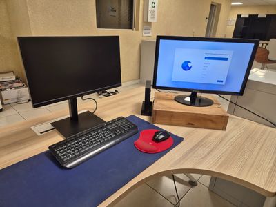 un bureau d'ordinateur avec deux écrans et un clavier