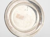 un plateau d'argent antique sur un support sur une surface blanche