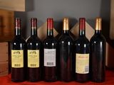 several bottles of red wine are lined up on a table