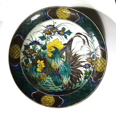 a decorative plate with a bird and flowers on it