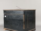 an old black chest with a wooden top and wooden legs