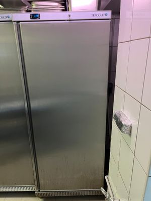 un réfrigérateur en acier inoxydable dans un coin de la salle de bains