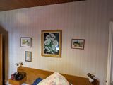 une chambre avec un lit, une commode et des tableaux accrochés au mur