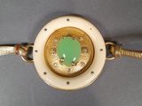 a gold and green bracelet with a green stone in the center