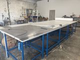 une photo d'un établi dans une usine, sur lequel se trouvent de nombreuses pièces en cours de fabrication