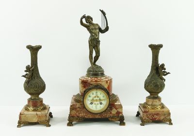 a clock and three vases sitting on a table