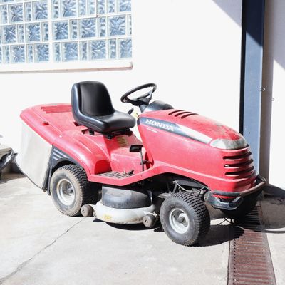 une tondeuse à gazon rouge garée devant un immeuble