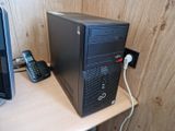 a desktop computer sitting on top of a desk next to a phone
