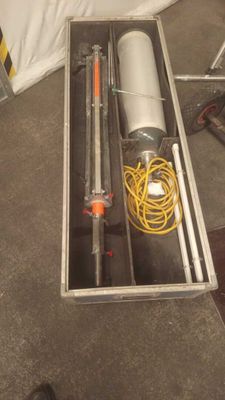 a metal box with a pipe and a hose in it