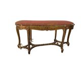 an image of a wooden bench with red upholstered seat