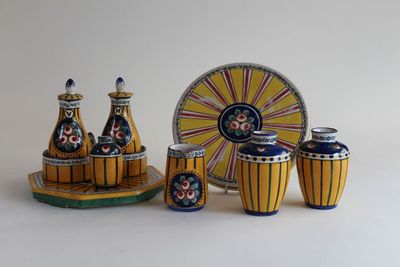 yellow and blue ceramic vases and a plate with a clock in the background