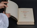 a person holding an open book on a table