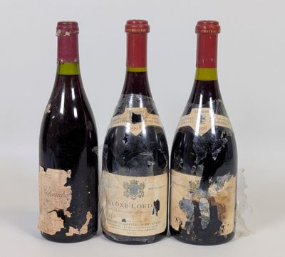 trois bouteilles de vin posées les unes à côté des autres sur une surface blanche