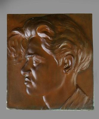 un gros plan sur une plaque en bronze représentant le visage d'un homme