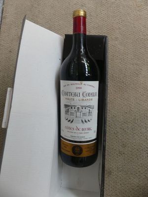 a bottle of wine sitting in a box on the floor
