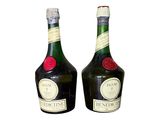 two bottles of liquor sitting next to each other on a white surface