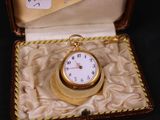 une petite montre de poche en or dans son étui