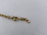 a close up of a gold bracelet on a white surface