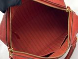 a person holding a red purse in their hand