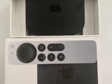 an apple tv sitting on top of a white box next to a remote