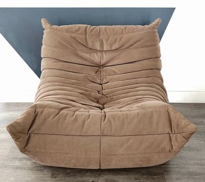 un pouf marron devant un mur orné d'un triangle bleu
