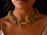 woman wearing a gold chain necklace and a white tank top