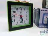 a green and black clock sitting next to a stack of boxes